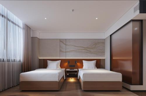 two beds in a hotel room with two beds sidx sidx sidx at Guangdong Baiyun City Hotel in Guangzhou