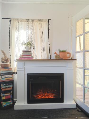 a fireplace with a fire in it in a living room at Maison de Lavande Farmstay in Benarkin