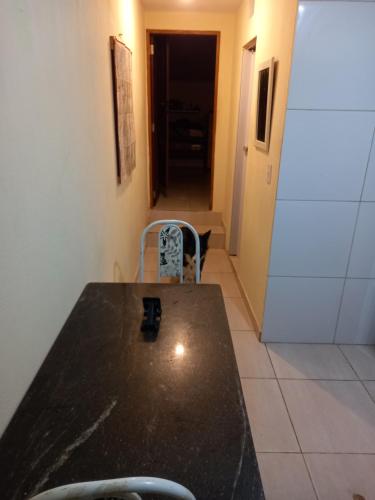 a table and chair in a room with a hallway at Hostel Luz in Lençóis