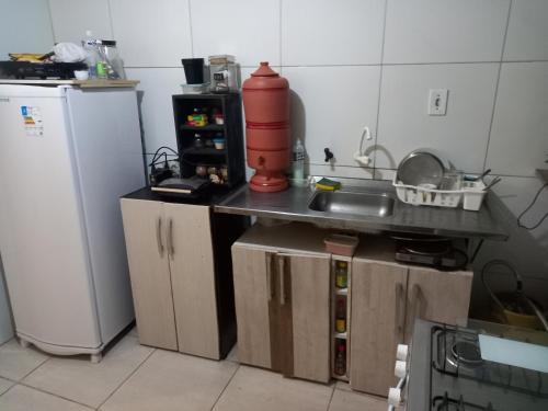 a small kitchen with a sink and a refrigerator at Hostel Luz in Lençóis
