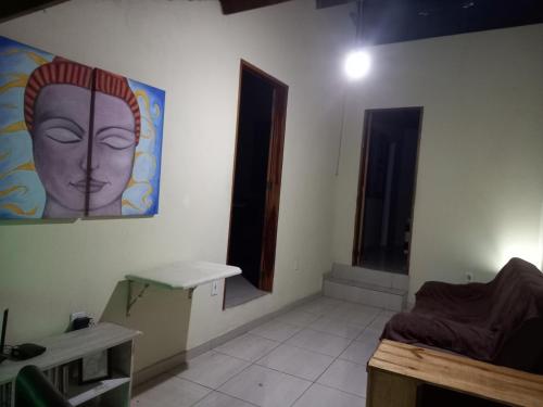 a room with a painting of a head on the wall at Hostel Luz in Lençóis