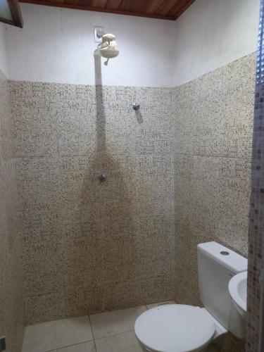 a bathroom with a shower with a toilet and a sink at Hostel Luz in Lençóis