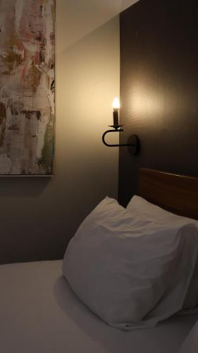 a bed with a white pillow and a candle on a wall at Casa Bruna Luxury Lofts in Tampico