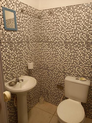 a bathroom with a white toilet and a sink at Hostel Luz in Lençóis