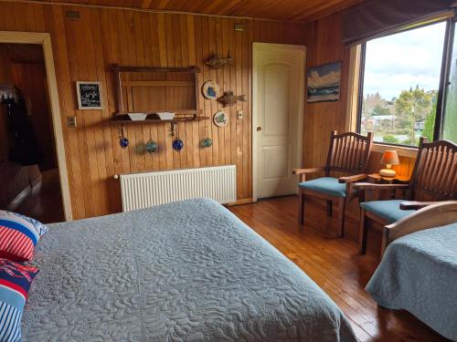 a bedroom with a bed and a table and chairs at Hostal Boutique El Vergel Azul in Castro
