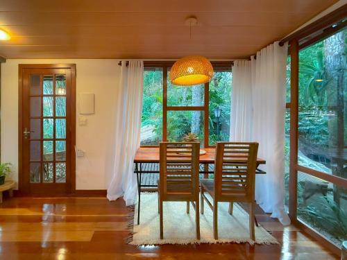 a dining room with a wooden table and chairs at Espaço Verde Novo Chalés in Teresópolis