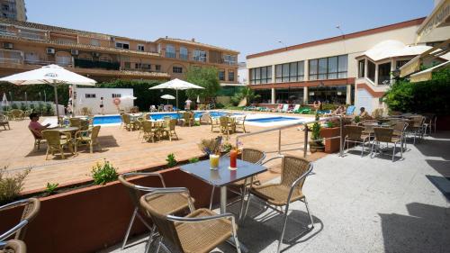 
a patio area with tables, chairs and umbrellas at Medplaya Hotel Balmoral in Benalmádena

