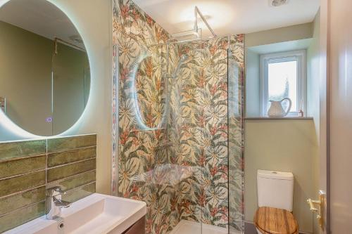 a bathroom with a shower with a sink and a toilet at Castell Coch in Llangwnadl