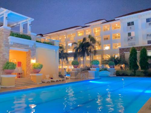a hotel with a swimming pool at night at Spacious Condo Staycation in Pasig City in Manila