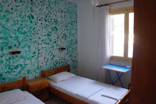 Habitación pequeña con 2 camas y ventana en Filippos, en Agios Kirykos