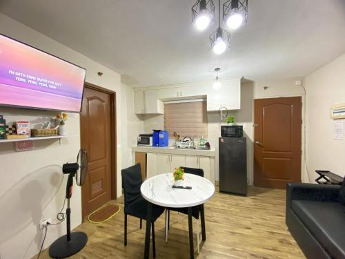 a small kitchen with a white table and a couch at Spacious Condo Staycation in Pasig City in Manila