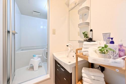 a bathroom with a shower and a sink at アロハベース in Takamatsu