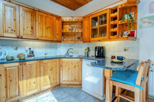 a kitchen with wooden cabinets and a counter top at Pengwern in Llangranog