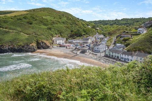 a coastal town with a beach and houses at Pengwern in Llangranog
