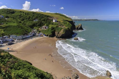 a group of people on a beach near the ocean at Pengwern in Llangranog