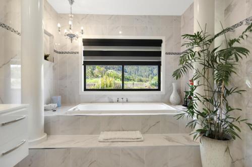 a white bathroom with a tub and a window at Casa Paradiso in Kororo Basin