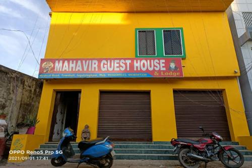 two motorcycles parked in front of a yellow building at Hotel O Mahavir Guest House in Cuttack