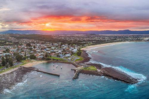 an aerial view of a beach at sunset at Shellharbour Seaview Luxury Escape in Shellharbour