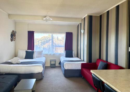 a hotel room with two beds and a couch at Parkside Motel and Apartments in New Plymouth