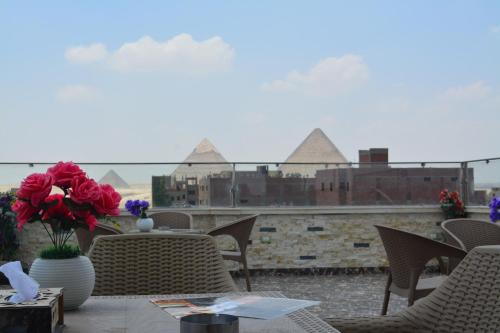 a patio with chairs and a table with flowers on it at king pyramids in Cairo