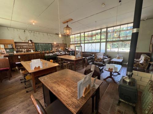 a restaurant with tables and chairs and a stove at 'Yamaneko Hotel 'Saunas, Serenity & Feline Friends in Miyoshi