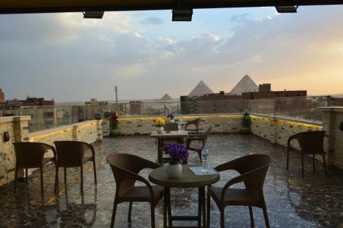 a view of the pyramids from a patio with tables and chairs at king pyramids in Cairo