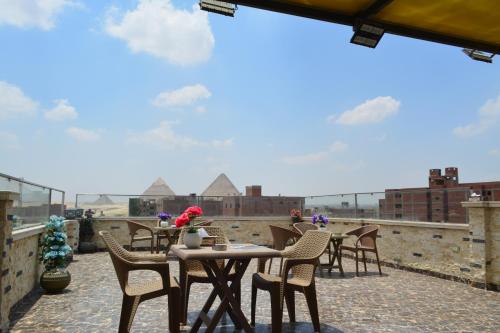 a table and chairs on the roof of a building at king pyramids in Cairo