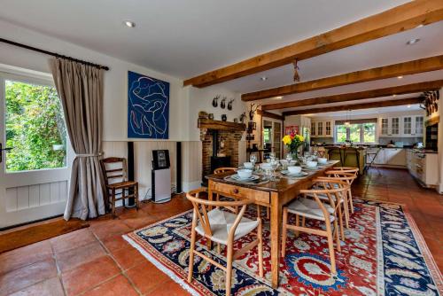a dining room with a wooden table and chairs at Denswood House in Brightling