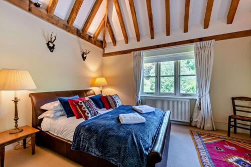 a bedroom with a bed and a large window at Denswood House in Brightling