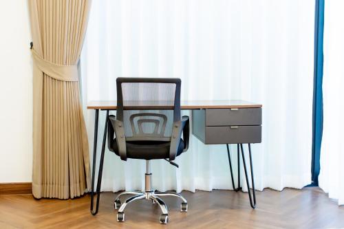 a desk with a chair next to a desk with a computer at Vita Villa - Modern 2BR At Heart of Phetchaburi in Phetchaburi