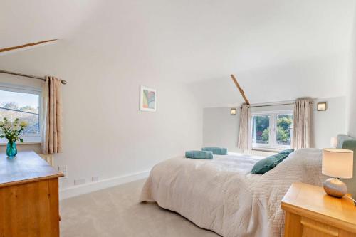 a bedroom with a large bed and two windows at The Granary - Ticehurst in Ticehurst