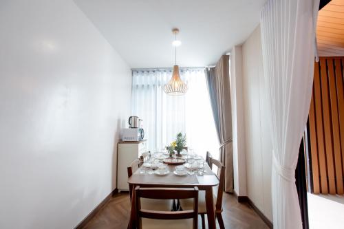 a dining room with a table with glasses on it at Vita Villa - Modern 2BR At Heart of Phetchaburi in Phetchaburi
