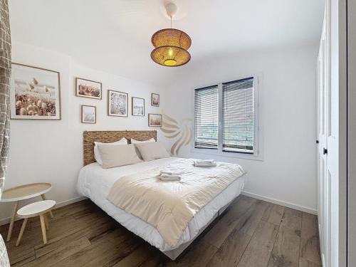 a white bedroom with a bed and a window at HorizSky Villa, 6p, 3BR, pool, WiFi in Saint-Raphaël
