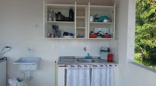 a kitchen with a sink in a white wall at Recanto verde pousada in Angra dos Reis