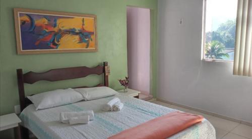 a bedroom with a bed with two towels on it at Recanto verde pousada in Angra dos Reis