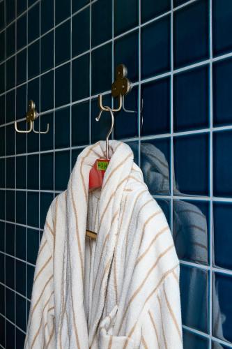 a robe hanging on a hanger in a bathroom at Hannah St Hotel Melbourne in Melbourne