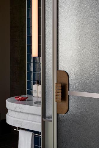 a bathroom with a mirror and a table with towels at Hannah St Hotel Melbourne in Melbourne