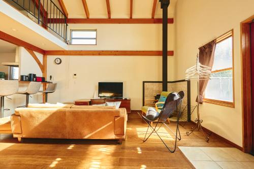a living room with a couch and a television at TOOD一宮-A棟 in Ichinomiya
