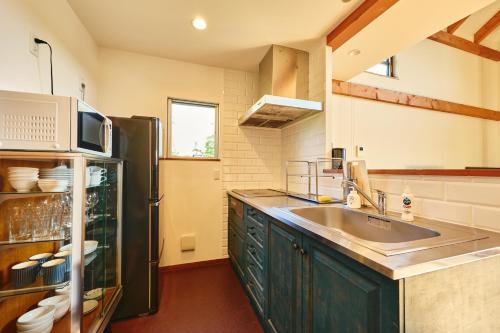 a kitchen with a sink and a refrigerator at TOOD一宮-A棟 in Ichinomiya