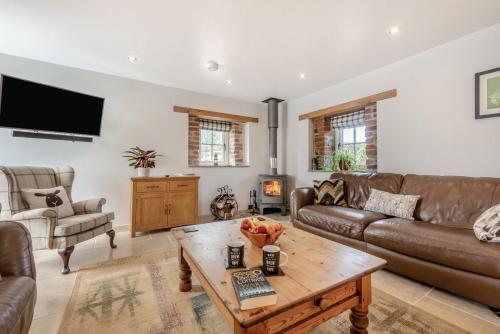 a living room with a couch and a coffee table at Paxton View Barn - Llanddarog in Llanddarog