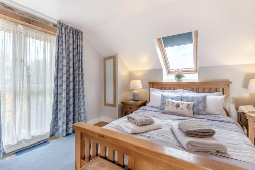 a bedroom with a large bed and a window at Paxton View Barn - Llanddarog in Llanddarog