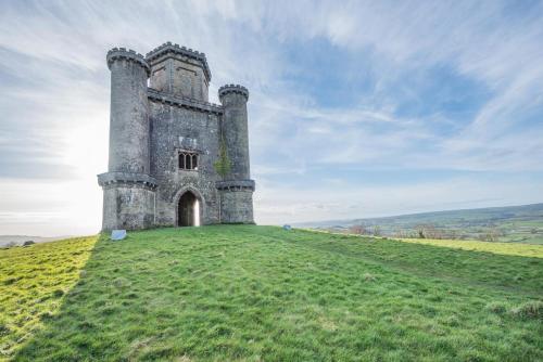 an old castle on top of a grassy hill at Paxton View Barn - Llanddarog in Llanddarog