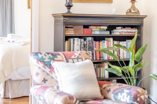 a living room with a couch and a book shelf with books at The Holt Barn in Tong