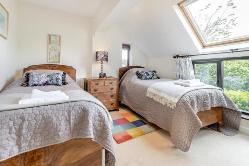 a bedroom with two beds and a window at The Holt Barn in Tong