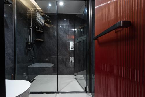 a bathroom with a glass shower with a toilet at Leshan Shengman Hotel in Leshan