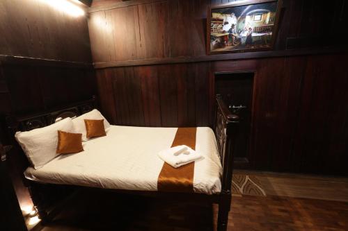 a small bed in a room with wooden walls at Castillo De Woods , The Private Luxury Villa , 8 BHK, Vattavada in Kottakamboor