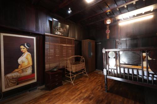 a room with a painting of a woman next to a crib at Castillo De Woods , The Private Luxury Villa , 8 BHK, Vattavada in Kottakamboor