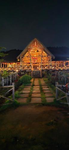 a large wooden building with lights on it at night at Sunny Guest House Hampi in Hampi