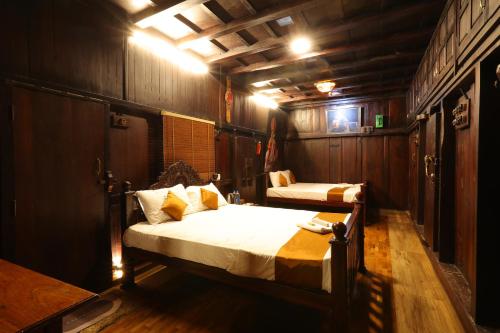 a bedroom with two beds in a room with wooden walls at Castillo De Woods , The Private Luxury Villa , 8 BHK, Vattavada in Kottakamboor