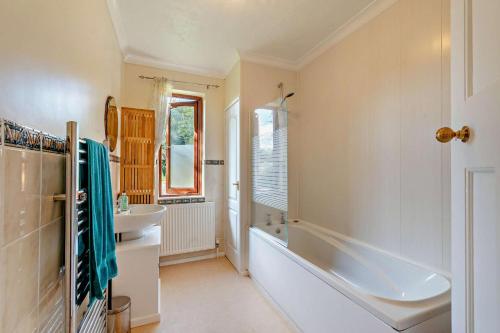 a bathroom with a tub and a sink at Willow House - Dymchurch in Dymchurch